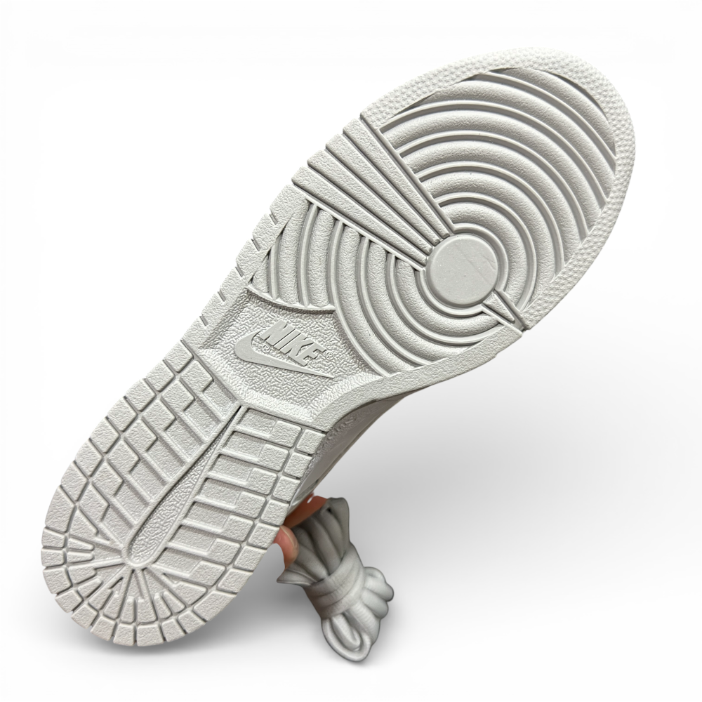 Bottom view of white rubber outsole with circular traction pattern and molded grooves